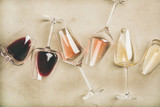 Flat-lay of red, rose and white wine in glasses over grey concrete background, top view. Wine bar, winery, wine degustation concept