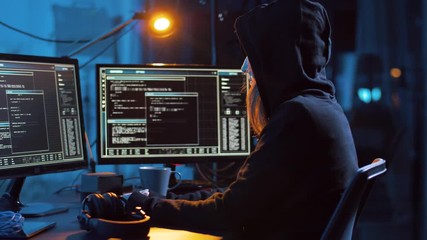 cybercrime, hacking and technology concept - female hacker in dark room creating code or using computer virus program for cyber attack