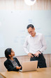 © Danon - A young Indian Asian woman is having a business meeting in an office with a Chinese Asian businessman. Both of them are young, attractive, and dressed professionally.
