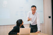 © Danon - A young Indian Asian woman is having a business meeting in an office with a Chinese Asian businessman. Both of them are young, attractive, and dressed professionally.