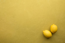Fresh Ripe Lemons On Yellow Stone Background. Top View With Copy Space.