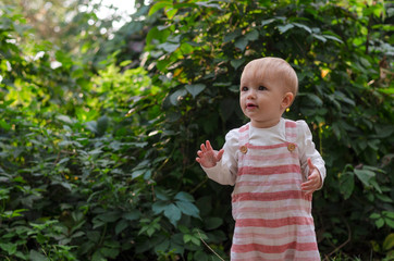 little cute baby girl walking on the trail in the park