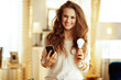 © Alliance - happy housewife with smartphone and smart lamp in modern house