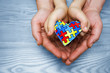 World Autism Awareness day, puzzle or jigsaw pattern on heart with autistic child's and father hands