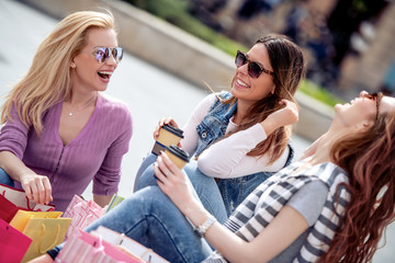 Wall Mural - Female friends resting with coffee after shopping