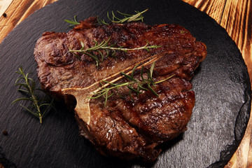 Wall Mural - Grilled T-bone steak on stone cutting board.