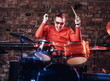 © Fxquadro - Emotional drummer plays at a night club performance against brick wall background. Photo with lighting motion effect