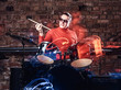 © Fxquadro - Emotional drummer plays at a night club performance against brick wall background. Photo with lighting motion effect