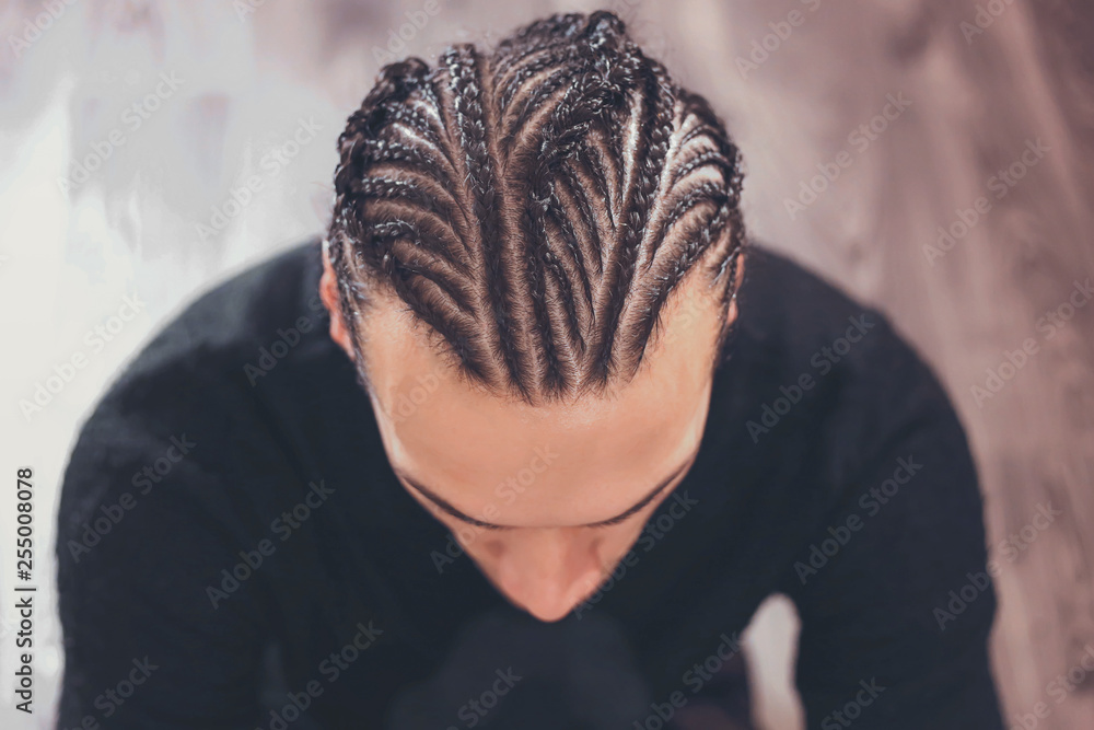 male hairstyle close-up braids, hair braided, pensive look, man portrait - obrazy, fototapety, plakaty 
