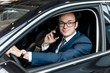 © pantovich - Businessman sitting behind the wheel of a car talking on a mobile phone