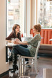 © ML Harris - Happy women friends talking, drinking coffee and having fun together in cafe