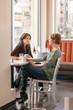 © ML Harris - Women friends talking having serious conversation and drinking coffee together in cafe. Woman listening to a friend.