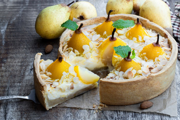 Wall Mural - Delicious cake with poached pears and almond flakes on wooden table