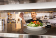 © ML Harris - Happy young Asian man chef cooking working preparing food in restaurant kitchen