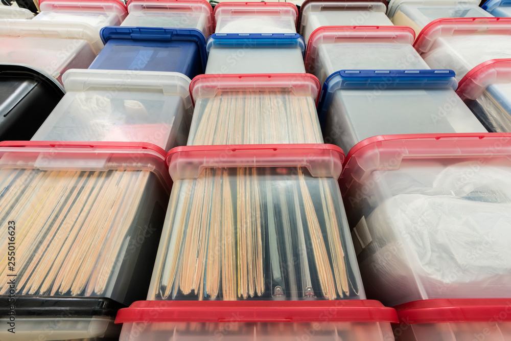 Tall wall of plastic file storage boxes with folders, binders and ...