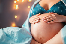 Unrecognizable Pregnant Woman Holding Her Belly At Home