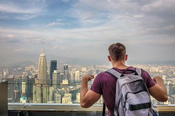 Fototapete - Tourist with a backpack enjoys the panoramic view of the Kuala Lumpur skyline