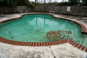 Dirty pool sits unattended covered in leaves