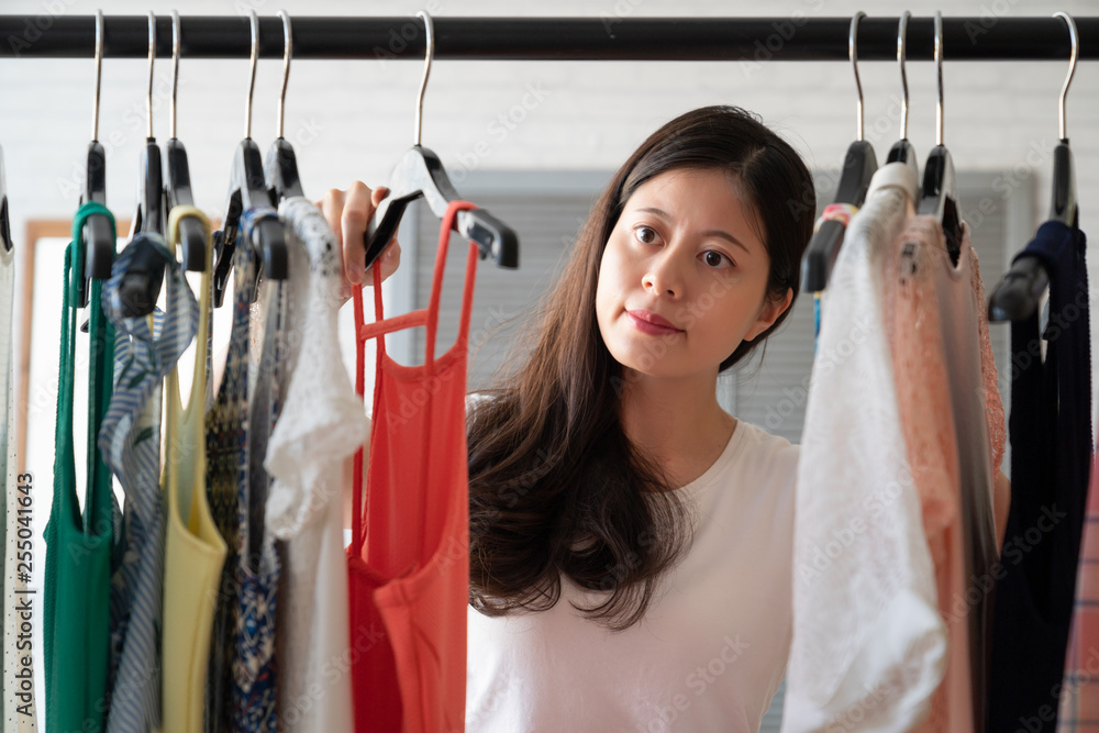Photo Stock clothing fashion style and people concept. elegant smiling woman choosing clothes standing near hanger at home wardrobe. happy female take down dress picking what to wear for today outfit in Photo Stock clothing fashion style and people concept. elegant smiling woman choosing clothes standing near hanger at home wardrobe. happy female take down dress picking what to wear for today outfit in