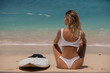 © South House Studio - fair-haired young woman sitting in sexy pose on pink sand beach turquoise ocean