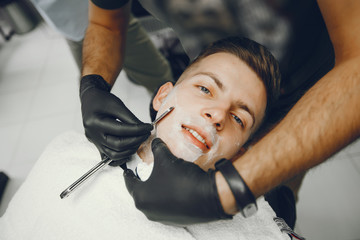 Wall Mural - A man in a barbershop. Clipping beard in the barber. Rest in hairdressing salon