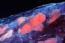 Crystals Of Major Industrial Lithium Ore Spodumene Showing Red Fluorescence In Ultraviolet Light (365 Nm).   Sample From Haapaluoma Lithium Quarry In Finland.