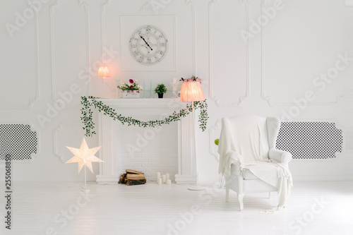 Bright White Living Room With A White Armchair And Fake Fireplace