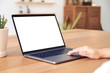 © Farknot Architect - Mockup image of hands using and touching on laptop touchpad with blank white desktop screen on wooden table