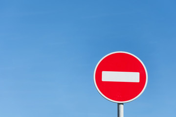 Round stop sign against a blue sky.