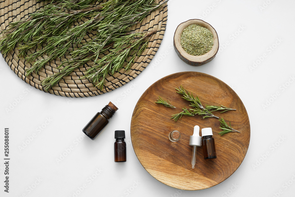 Bottles of rosemary oil on white background