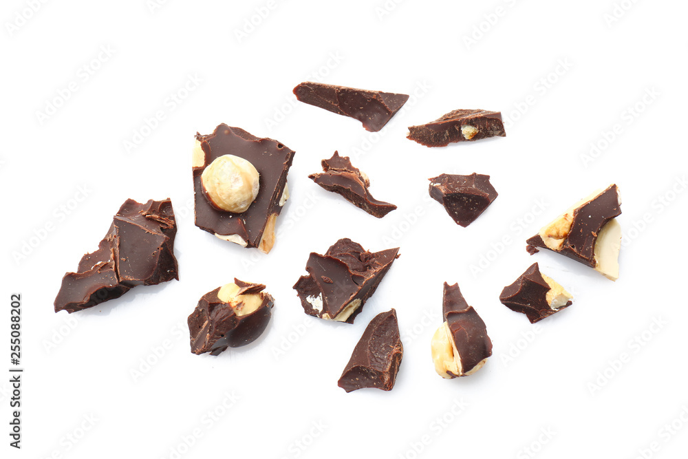 Pieces of tasty dark chocolate with nuts on white background