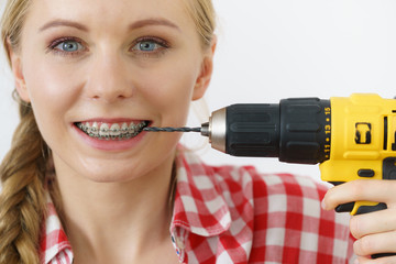 Wall Mural - Woman with braces using drill on her teeth