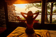 © yurakrasil - Young woman on f the house in the beautiful forest panoramic windows eco hotel in the jungle