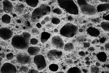 The Holes On The Porous Sponge For Washing Dishes Close Up Black And White