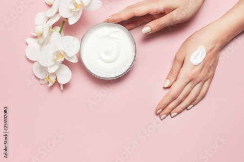 Fotografía Young woman moisturizes her hand with cosmetic cream lotion opened container wit