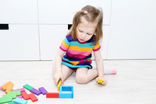 Lovely Little Girl Playing With Educational Toy At Home