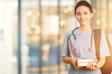 Canvas Print - Attractive young female doctor student on background