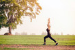 © Sirirat Makprasert - Runner athlete running at green area.Young woman doing yoga exercise yoga master pose Amazing yoga landscape in beautiful and enjoying view, fitness silhouette sunrise jogging workout wellness concept