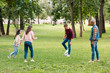 © LIGHTFIELD STUDIOS - cheerful multicultural group of friends playing football in park