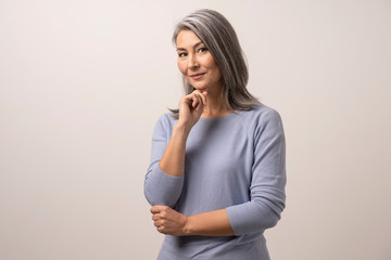 Elegant adult woman of mongolian nationality on a white background.