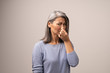 © Svyatoslav Lypynskyy - Mature Asian woman holding her nose because of a bad smell