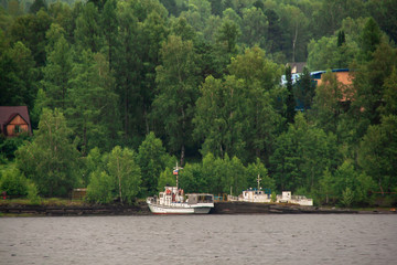 Wall Mural - summer landscape on a mountain lake. fog over forest. ships and boats floating near the shore on the water