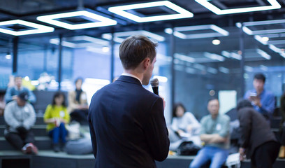 Fototapete - Speaker at Talk in Business Conference. Tech Executive Entrepreneur Speaker on Stage at Conference. Presenter Giving Business Presentation at Meeting. Corporate Exhibition for Investors Event.
