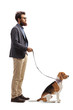 Bearded man standing with a beagle dog on a leash