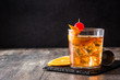 canvas print picture - Old fashioned cocktail with orange and cherry on wooden table. Copyspace