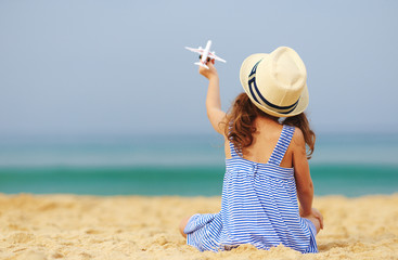 Wall Mural - child girl with toy model airplane on the sea on the beach    .