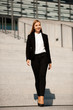 © Samo Trebizan - Young business woman walk on stairs leaving office building