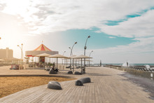 View Of Namal Promenade At Tel Aviv Port, Israel. Sunset At Harbour Deck With Carousel And Sunshades By The Sea.