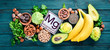 Foods containing natural magnesium. Mg: Chocolate, banana, cocoa, nuts, avocados, broccoli, almonds. Top view. On a blue wooden background.
