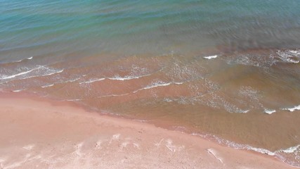 Wall Mural - Flying over a lonely beach in Denia, Spain. Small waves on the sea